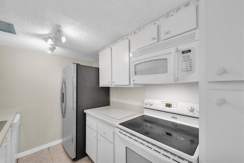 171 Medallion Boulevard, Unit F Madeira Beach, FL 33708 - Photo 10 of 30 a kitchen with a cabinets and steel stainless steel appliances