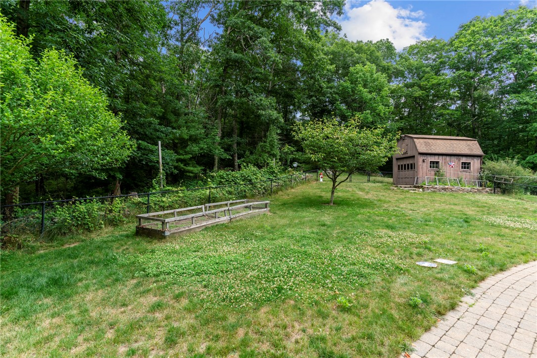 252 Log Bridge Road Coventry, RI 02816 - Photo 34 of 36 View from inside the fenced area back of house with paved walk-way, garden bed and shed