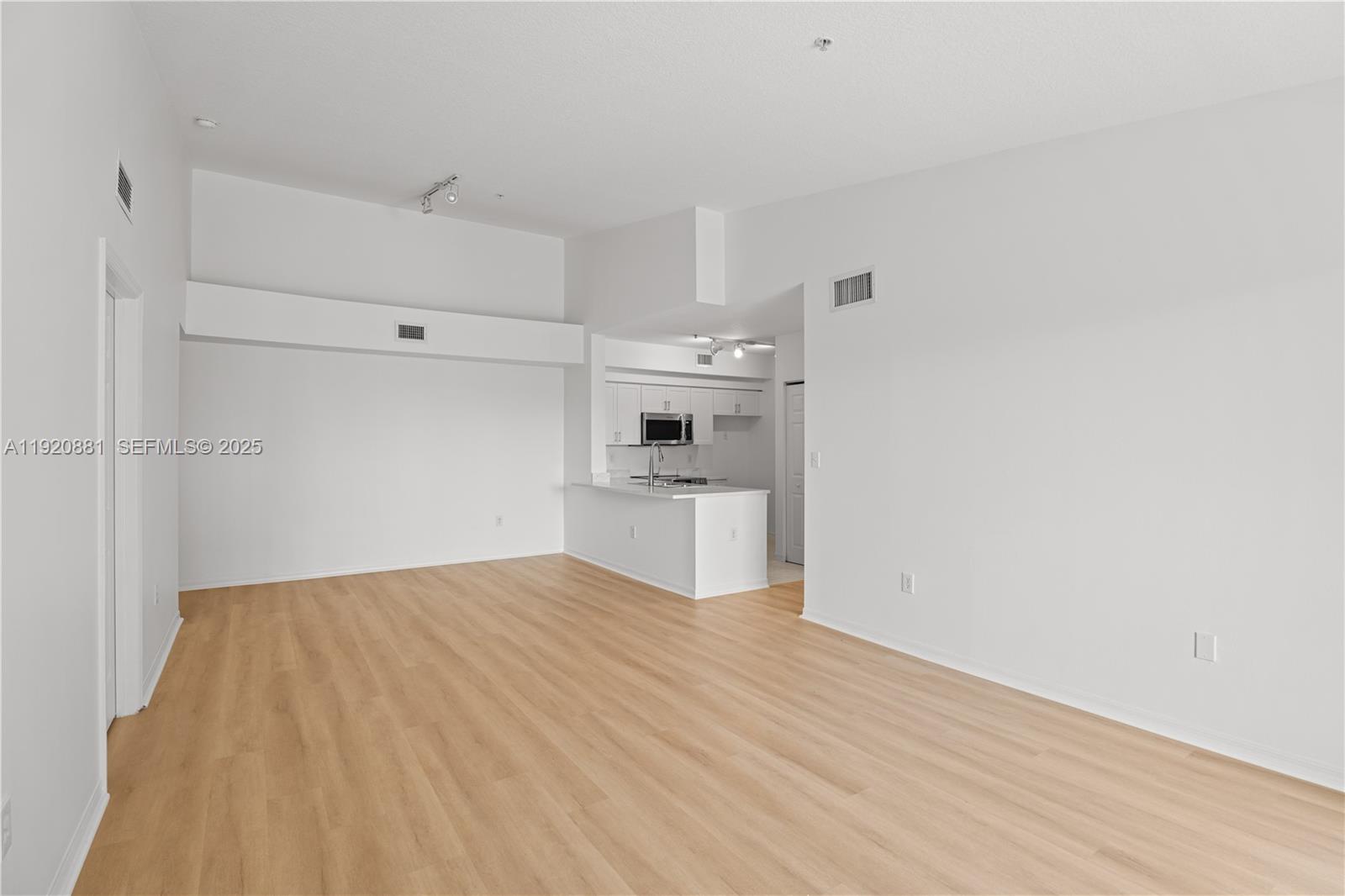 6821 Southwest 44th Street, Unit 203 Miami, FL 33155 - Photo 8 of 28 a view of a kitchen with white cabinets and wooden floor