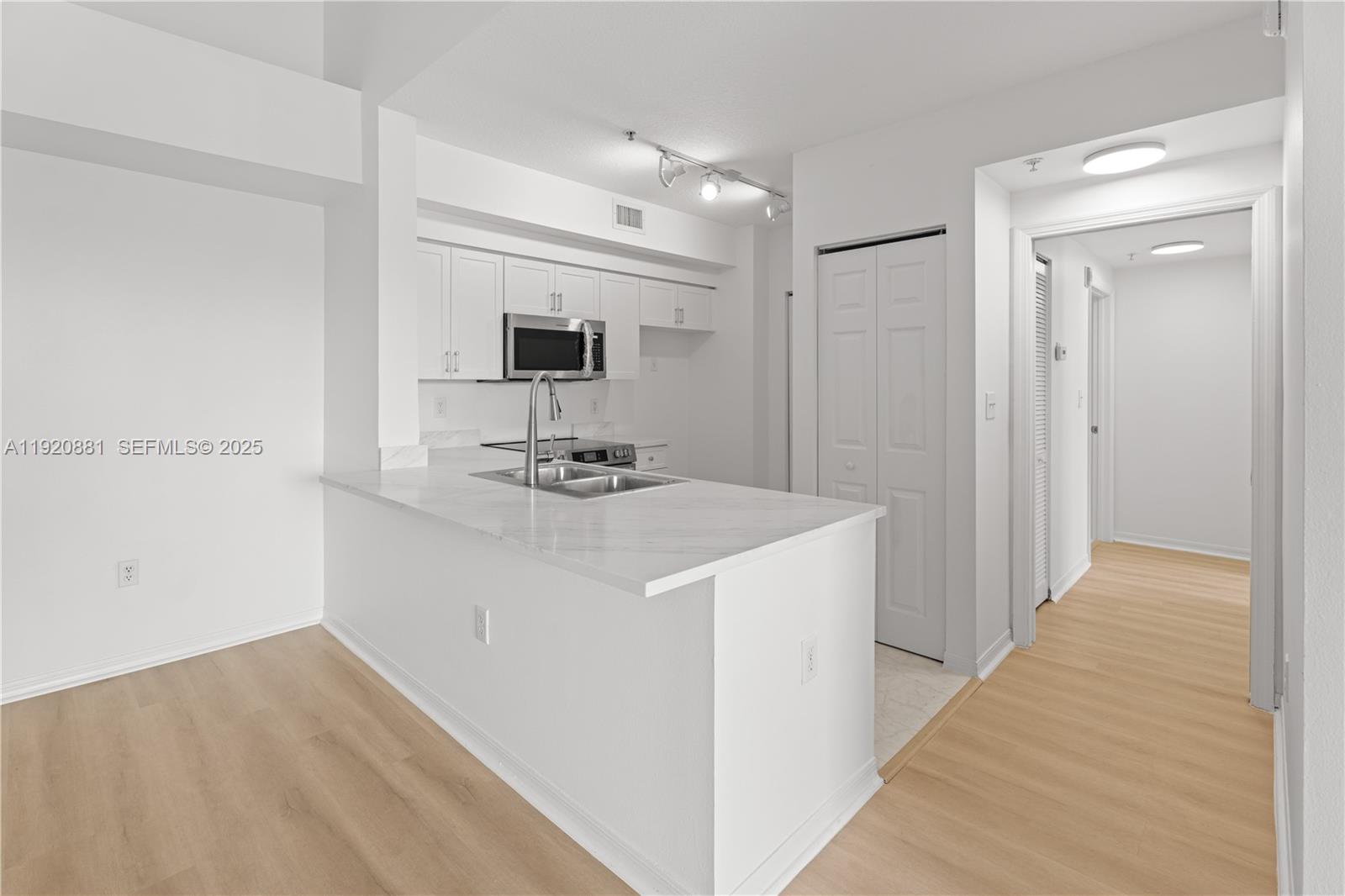 6821 Southwest 44th Street, Unit 203 Miami, FL 33155 - Photo 9 of 28 a kitchen with kitchen island a sink appliances and cabinets
