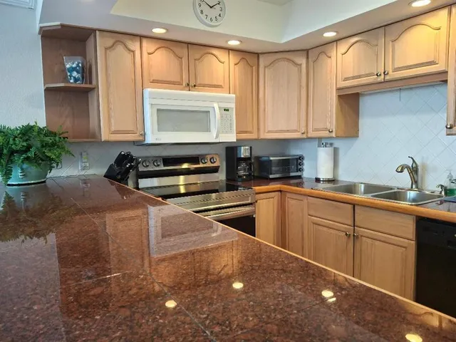 a kitchen with stainless steel appliances granite countertop a sink stove and cabinets