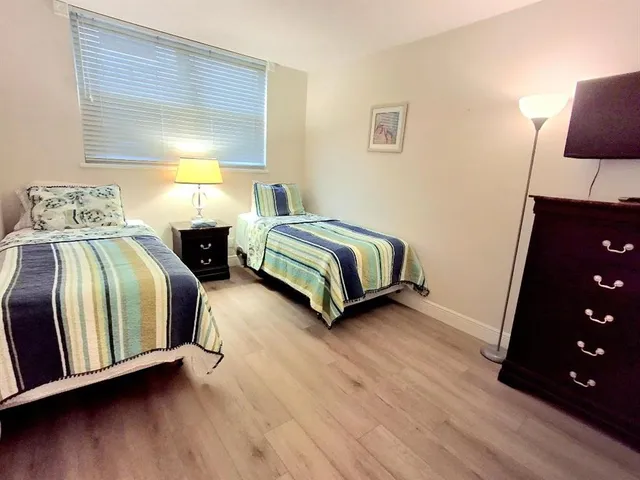 a bedroom with two beds and painting on the wall