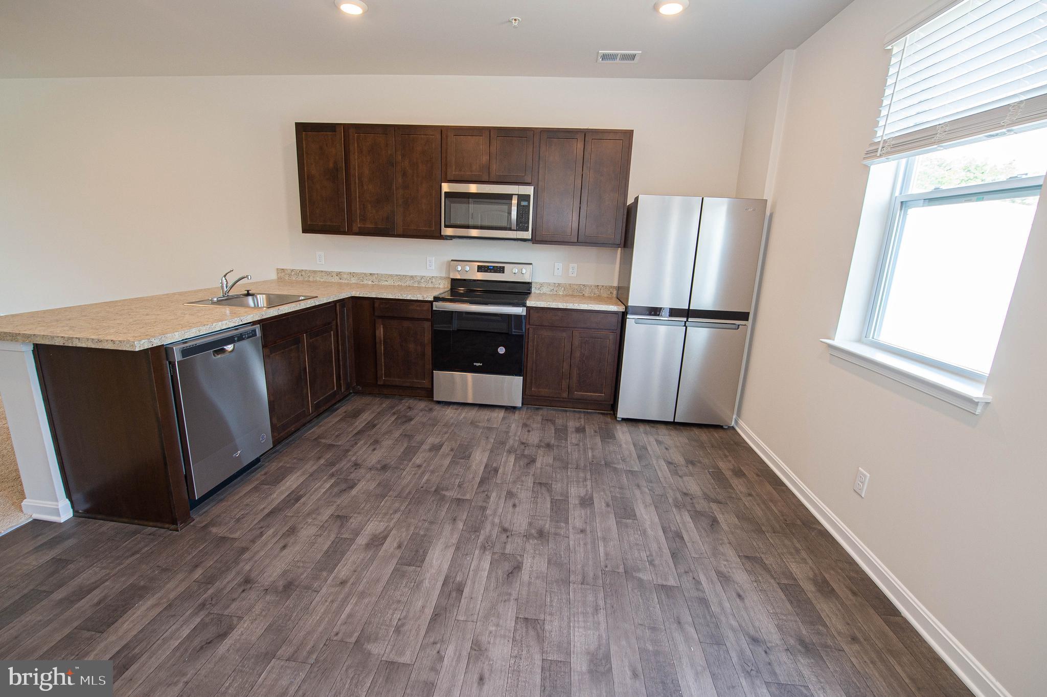 126 Willowtree Lane Fruitland, MD 21826 - Photo 23 of 68 a kitchen with a refrigerator stove and wooden floor