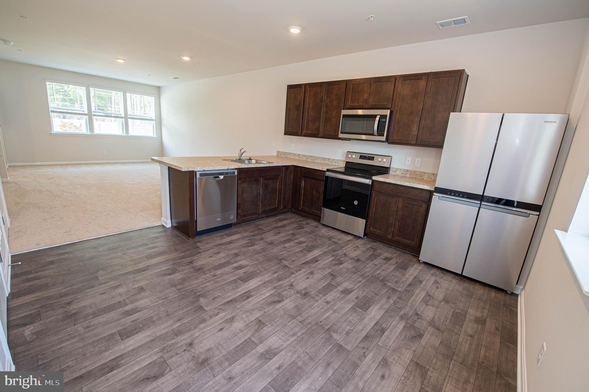 126 Willowtree Lane Fruitland, MD 21826 - Photo 24 of 68 a kitchen with granite countertop a refrigerator and a stove top oven
