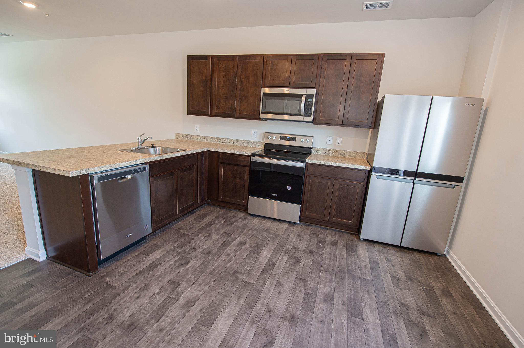 126 Willowtree Lane Fruitland, MD 21826 - Photo 25 of 68 a kitchen with stainless steel appliances granite countertop a refrigerator a stove a sink and a microwave