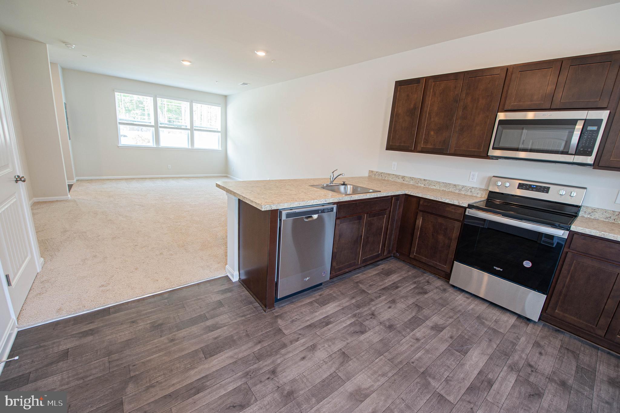 126 Willowtree Lane Fruitland, MD 21826 - Photo 31 of 68 a kitchen with stainless steel appliances granite countertop a stove a sink and a microwave