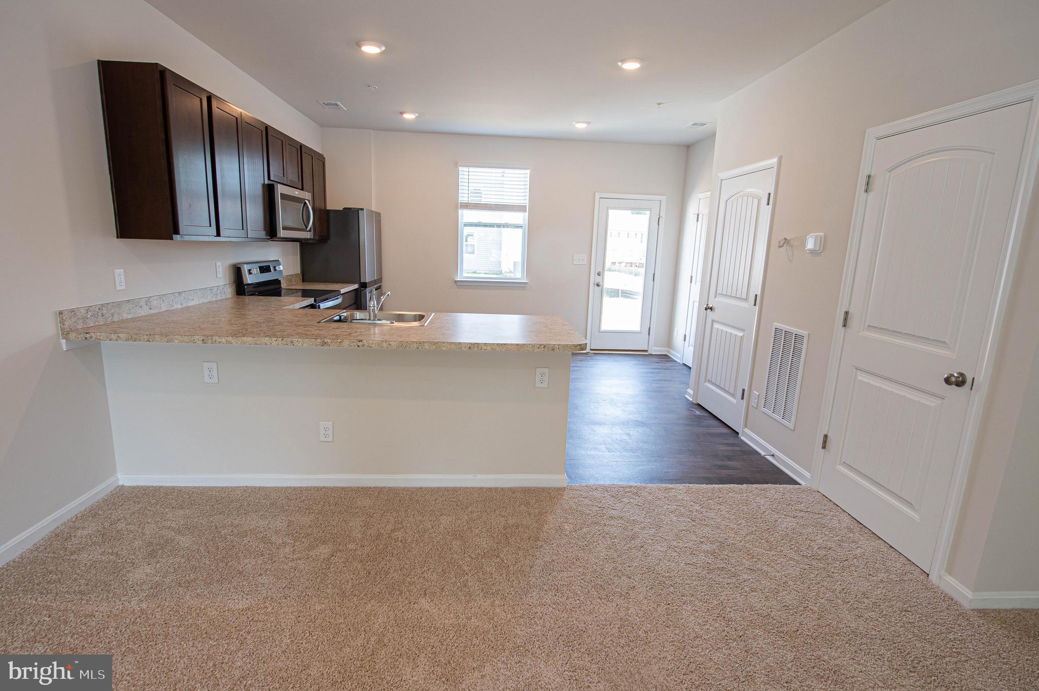 126 Willowtree Lane Fruitland, MD 21826 - Photo 36 of 68 a view of a kitchen with a sink and dishwasher a refrigerator with wooden floor