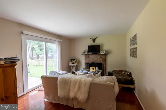 a living room with furniture a fireplace and a large window