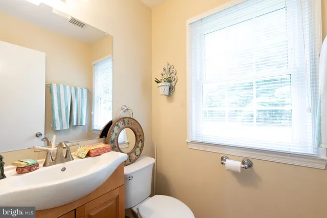a bathroom with a sink a toilet and a window
