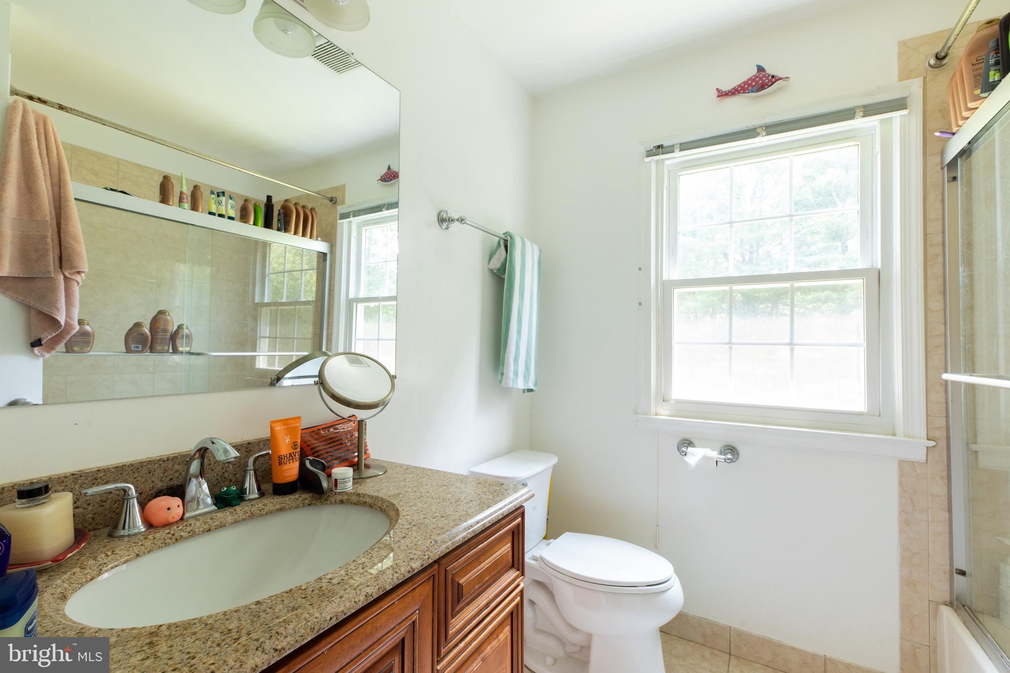 2527 Lindley Terrace Rockville, MD 20850 - Photo 20 of 31 a bathroom with a granite countertop sink mirror vanity and toilet