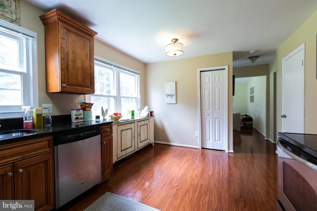 a kitchen with a refrigerator a sink and wooden floor