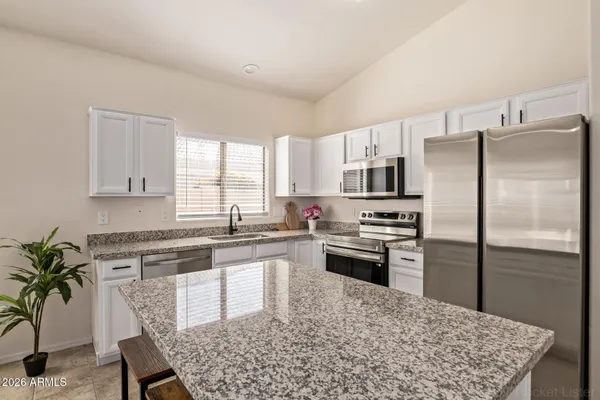 a kitchen with a refrigerator and a stove top oven