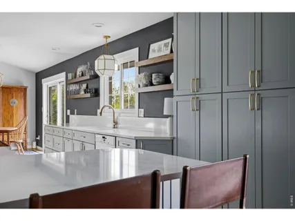a view of a living room and a kitchen with stainless steel appliances