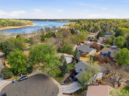 an aerial view of residential houses with outdoor space and lake view