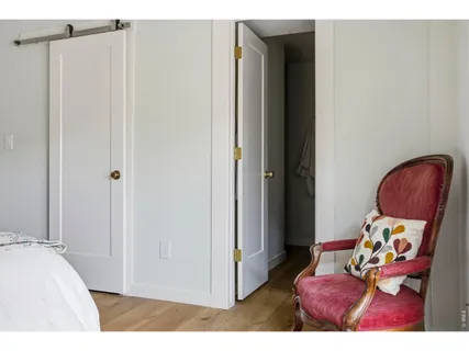 a bedroom with a large bed and two windows