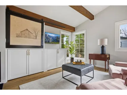 a living room with furniture a window and a flat screen tv