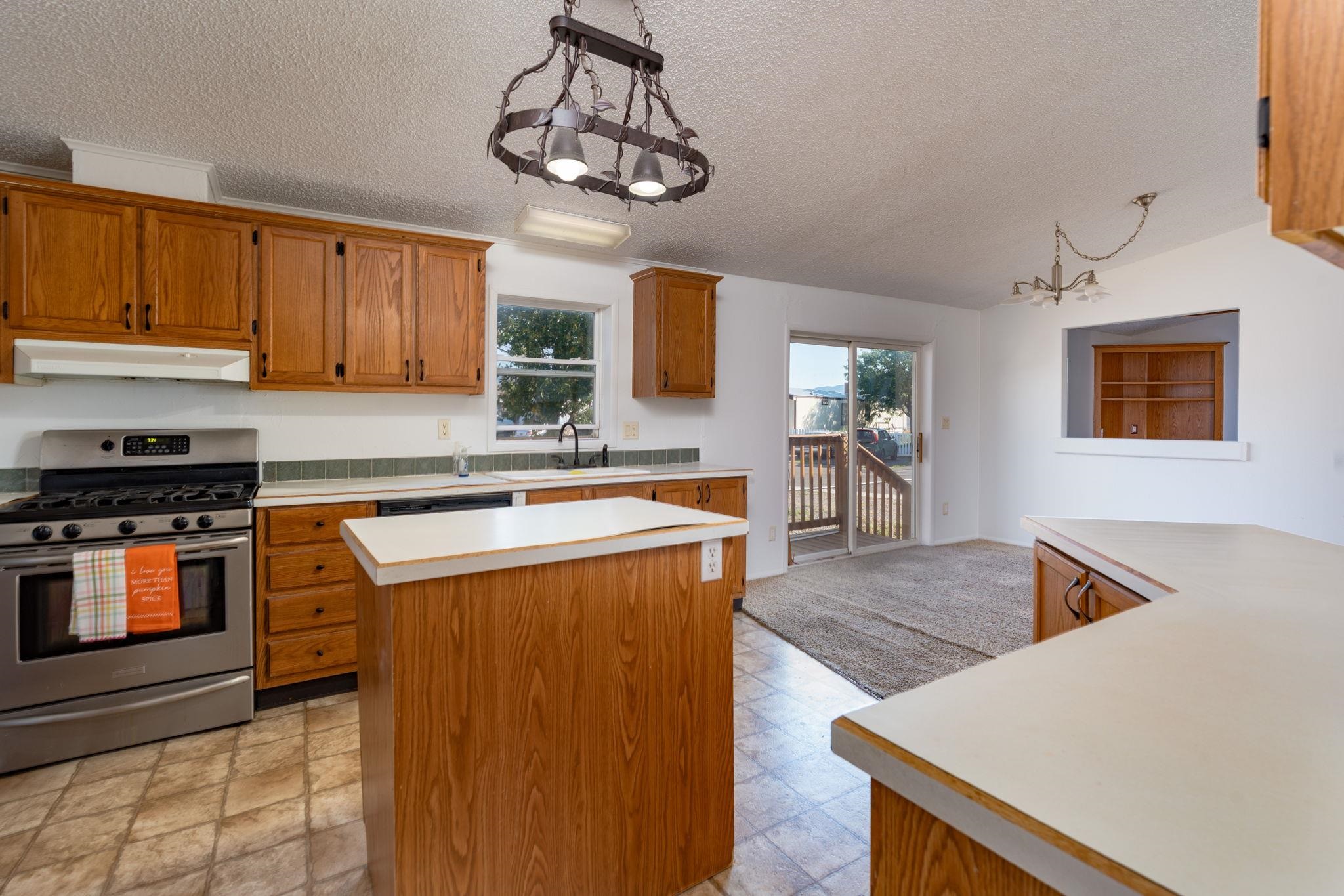424 32 Road, Unit 284 Clifton, CO 81520 - Photo 12 of 21 a kitchen with stainless steel appliances granite countertop a sink dishwasher stove top oven and cabinets with wooden floor