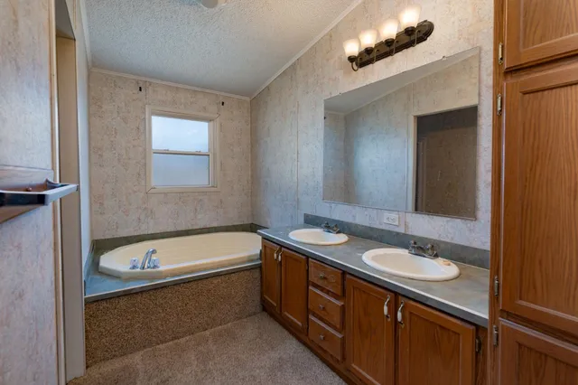 a bathroom with a tub a sink and mirror