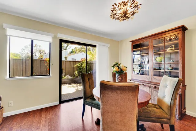 a dining room with furniture wooden floor a potted plant and a chandelier