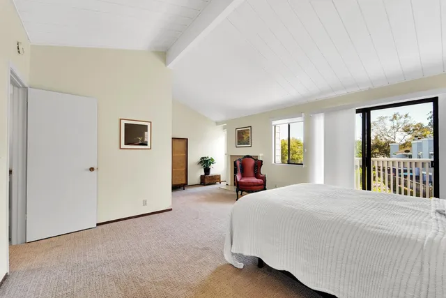 a bedroom with bed and a large window