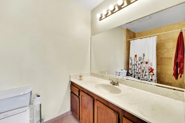 a bathroom with a granite countertop sink and a large mirror