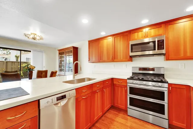 a kitchen with stainless steel appliances a stove microwave and sink