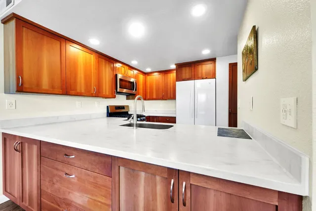 a kitchen with stainless steel appliances a refrigerator sink and cabinets