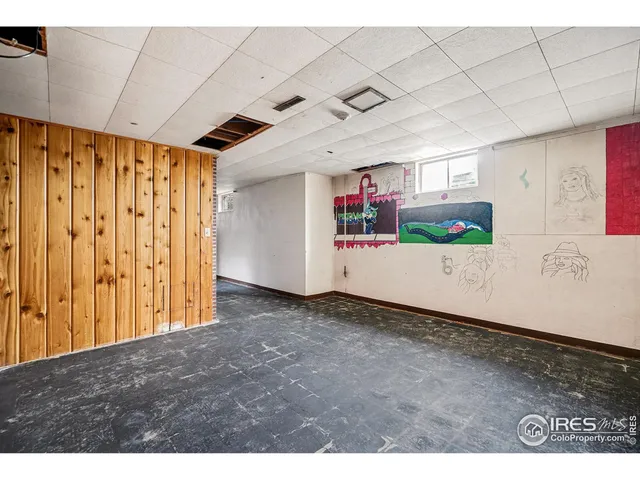 a view of an empty room with a fireplace and a window