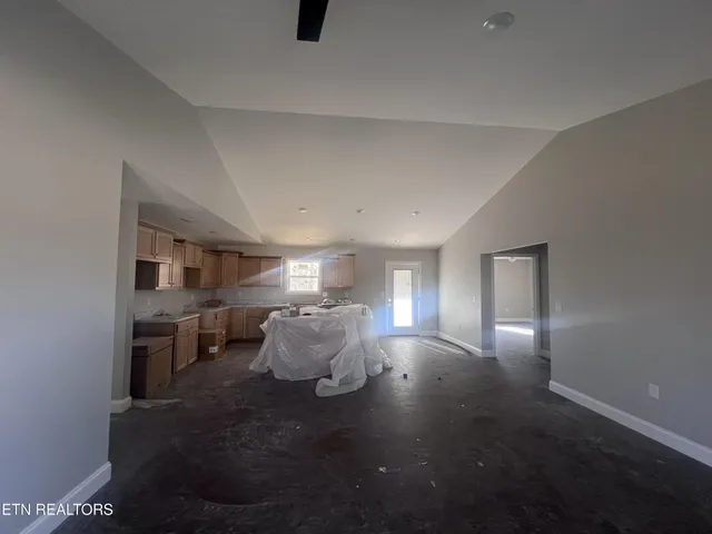 an empty room with a window and a ceiling fan