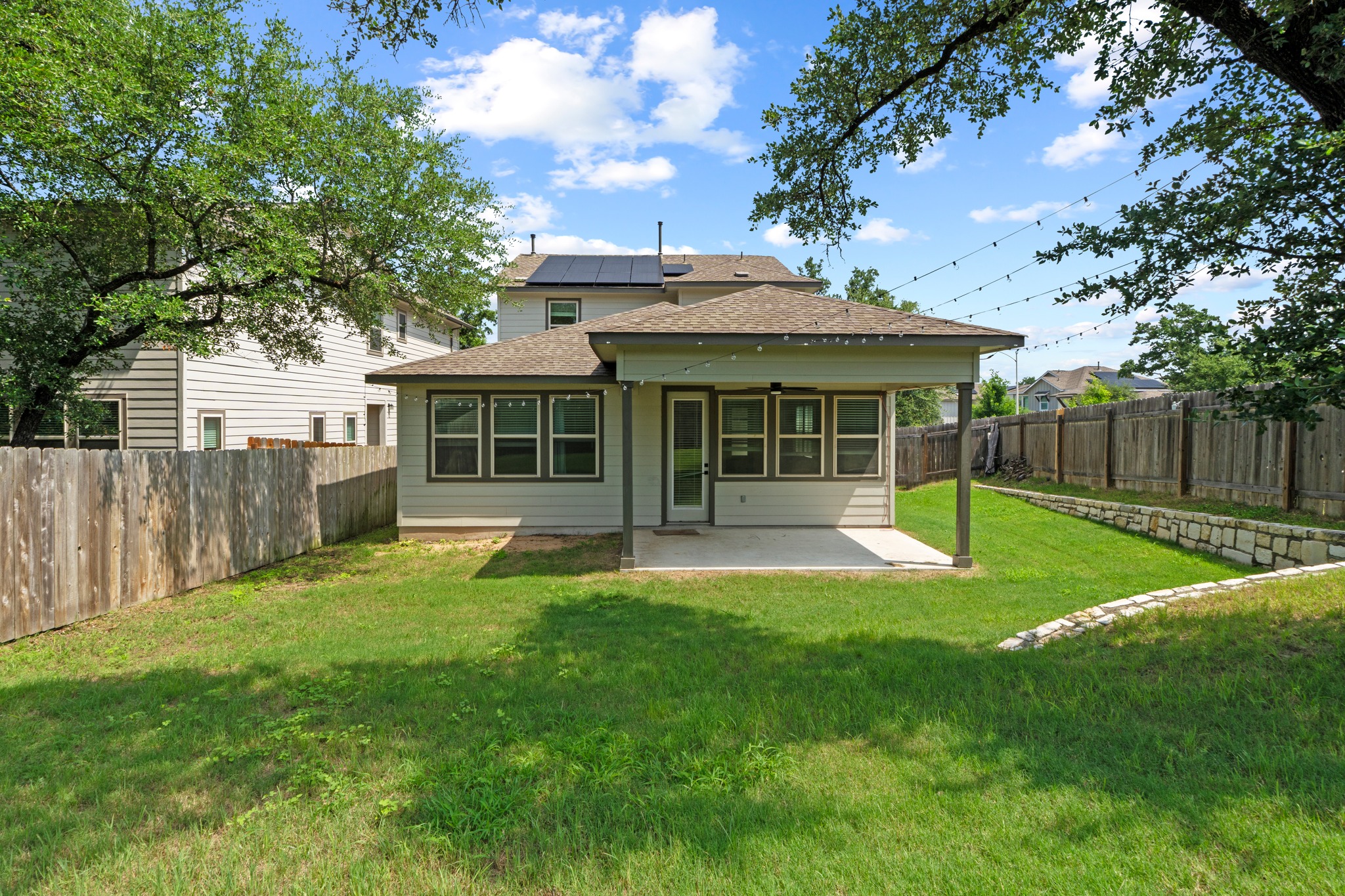 1101 Skeeter Cove Austin, TX 78748 - Photo 31 of 31 A spacious yard with covered patio for relaxed outdoor living, surrounded by mature trees.