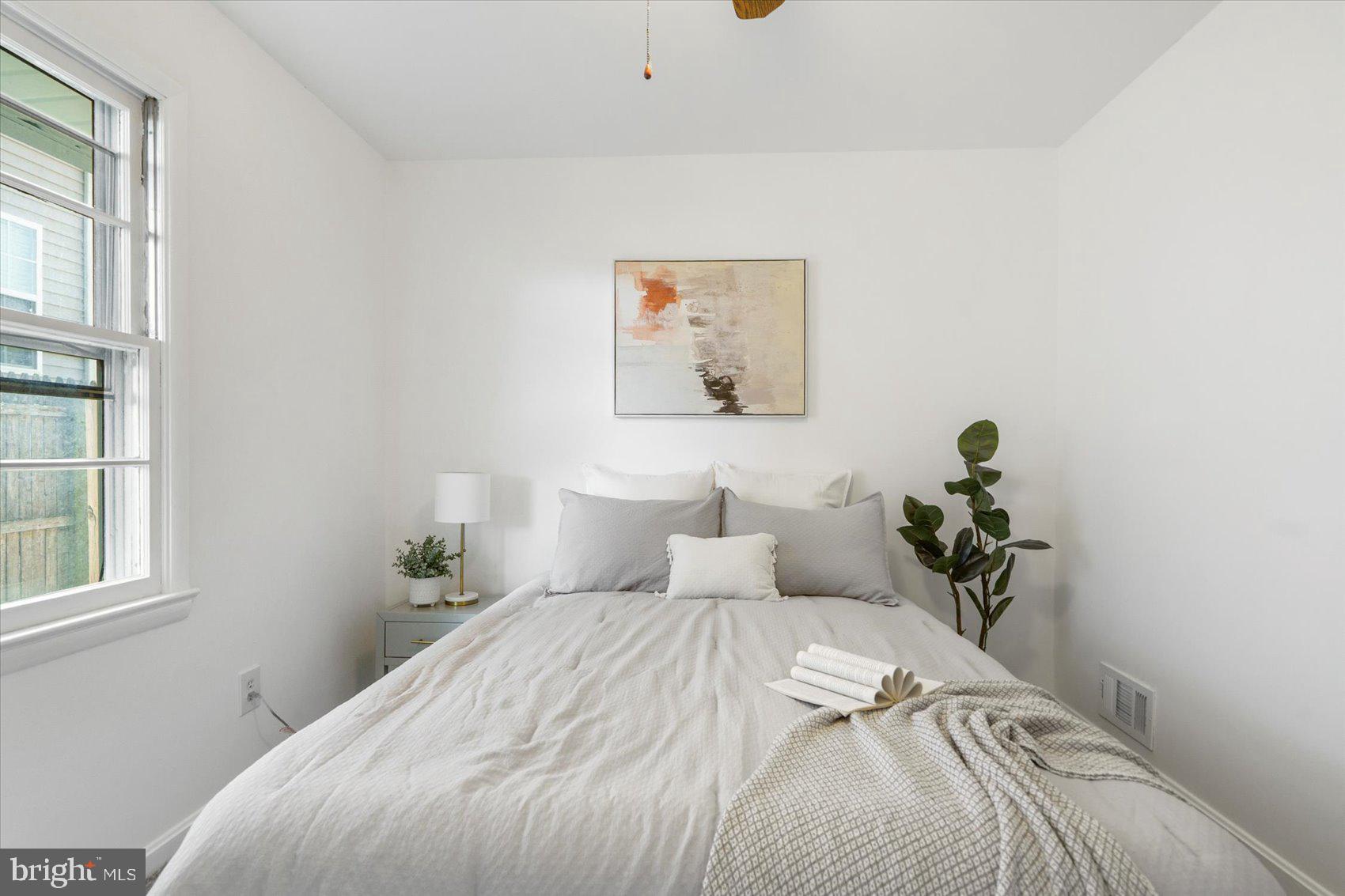 2440 East Biddle Street Baltimore, MD 21213 - Photo 19 of 35 a bedroom with a bed and a potted plant