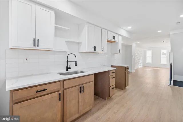 a kitchen with a sink cabinets and wooden floor