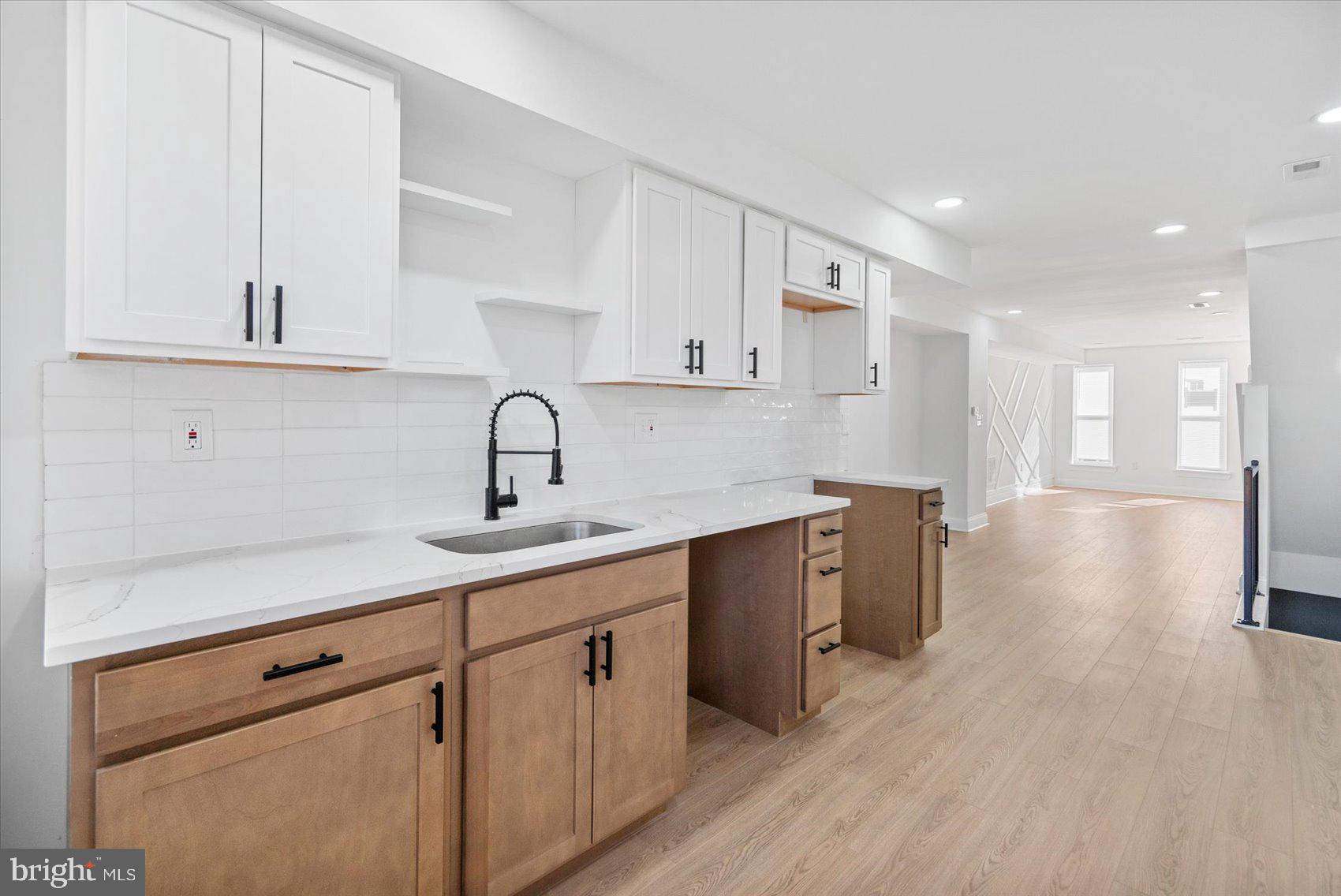 2440 East Biddle Street Baltimore, MD 21213 - Photo 9 of 35 a kitchen with a sink cabinets and wooden floor