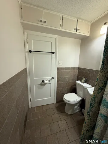 a bed sitting in a spacious bedroom next to a window and a chair