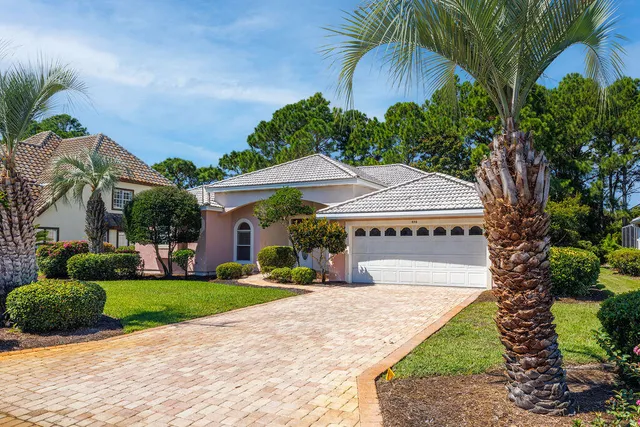 a front view of a house with a yard and potted plants