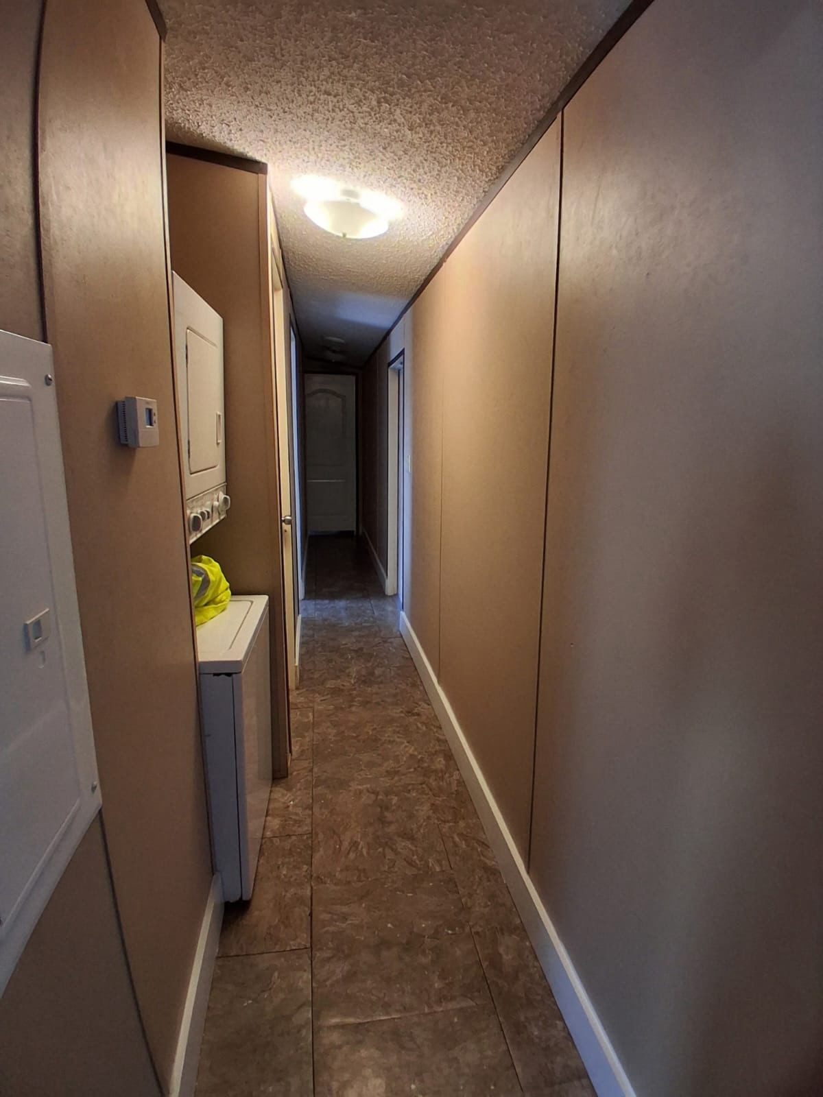 130 Gato Road Cedar Creek, TX 78612 - Photo 18 of 23 Corridor featuring stacked washer / drying machine and baseboards