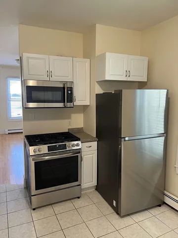 a kitchen with refrigerator and cabinets