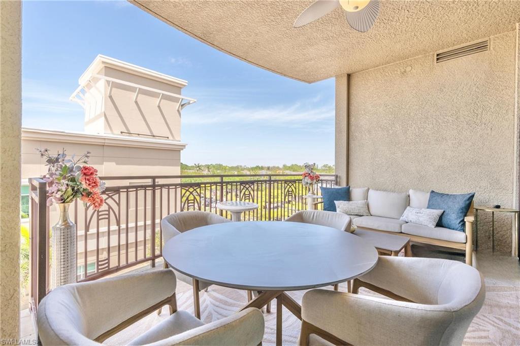 9115 Strada Place, Unit 5317 Naples, FL 34108 - Photo 15 of 29 a balcony with furniture and wooden floor