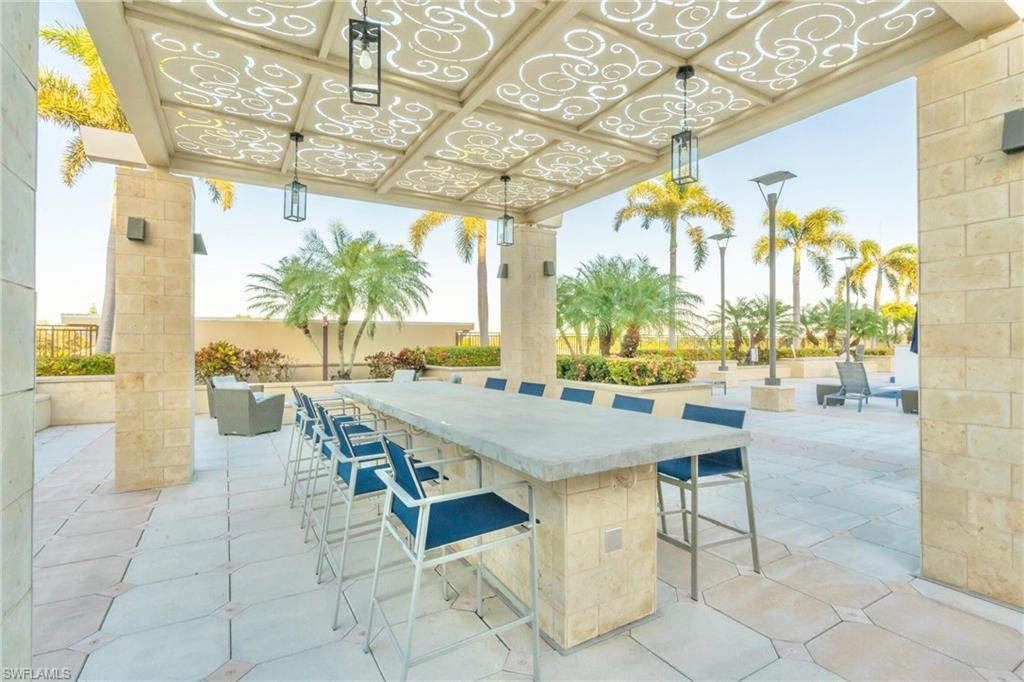 9115 Strada Place, Unit 5317 Naples, FL 34108 - Photo 22 of 30 a view of a patio with a table and chairs and potted plants