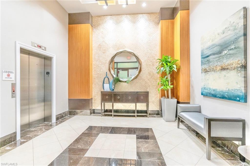 9115 Strada Place, Unit 5317 Naples, FL 34108 - Photo 28 of 30 a living room with a couch a table and a potted plant