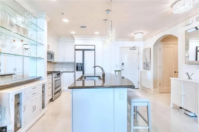 a large kitchen with stainless steel appliances kitchen island granite countertop a sink and cabinets