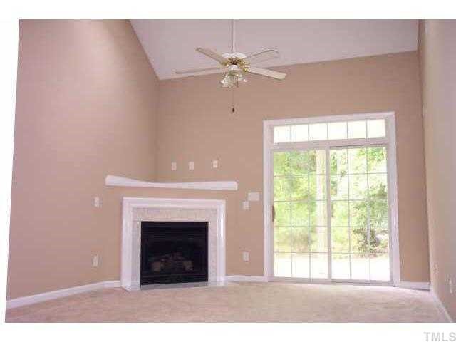3036 Coxindale Drive Raleigh, NC 27615 - Photo 5 of 10 a living room with a fireplace and a chandelier