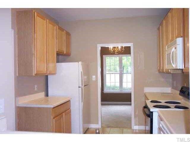 3036 Coxindale Drive Raleigh, NC 27615 - Photo 6 of 10 a kitchen with stainless steel appliances granite countertop a refrigerator a sink dishwasher and white cabinets with wooden floor