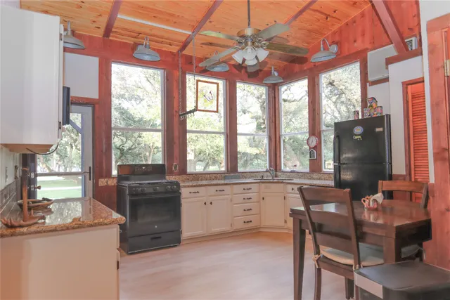 a kitchen with granite countertop white cabinets and a window
