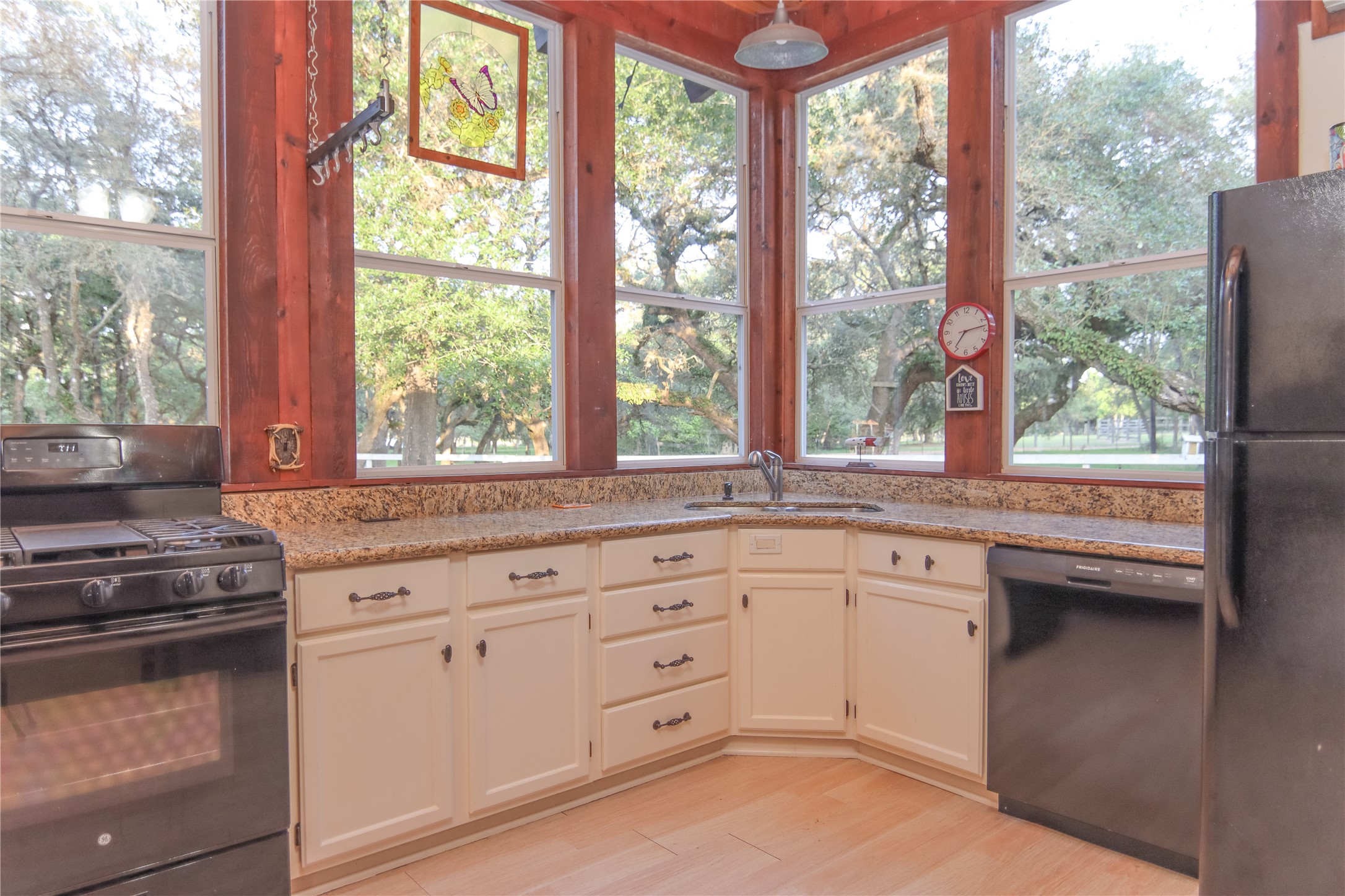 302 Bluebonnet Bend Sheridan, TX 77475 - Photo 20 of 29 a kitchen with granite countertop white cabinets and a window