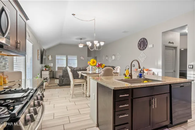 a kitchen with a sink a stove and chairs