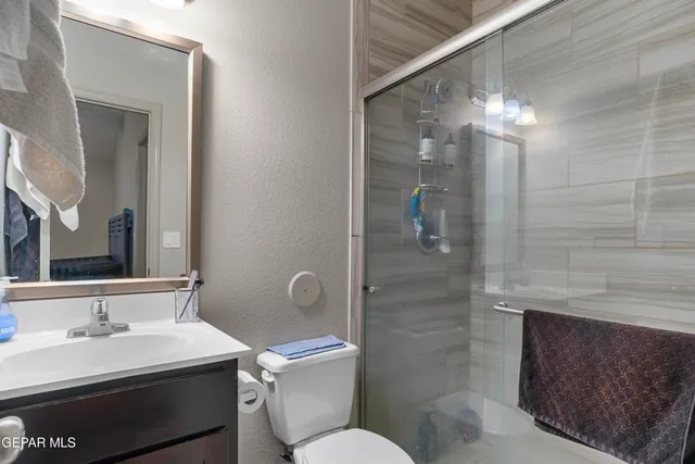 a bathroom with a sink a toilet and shower