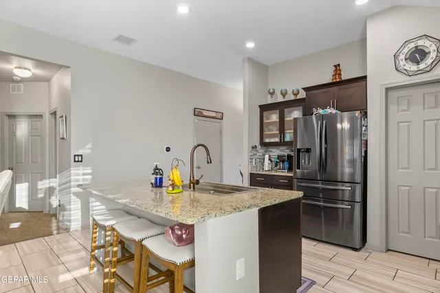 a kitchen with stainless steel appliances granite countertop a refrigerator and a stove top oven