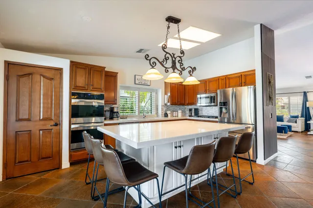a dining room with stainless steel appliances wooden floor dining table and chairs