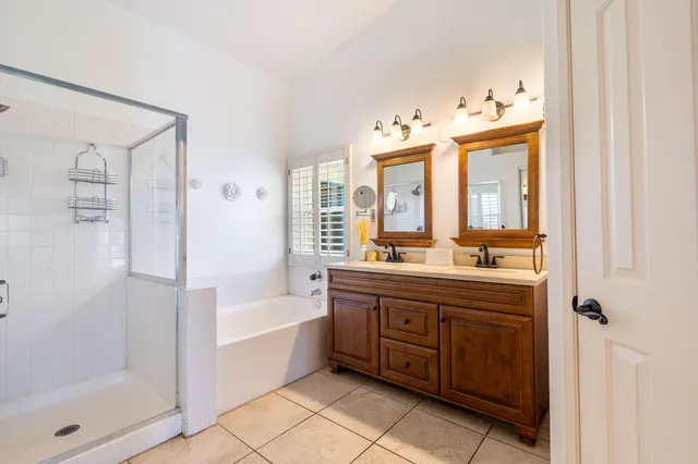 a spacious bathroom with a double vanity sink a mirror and a bathtub